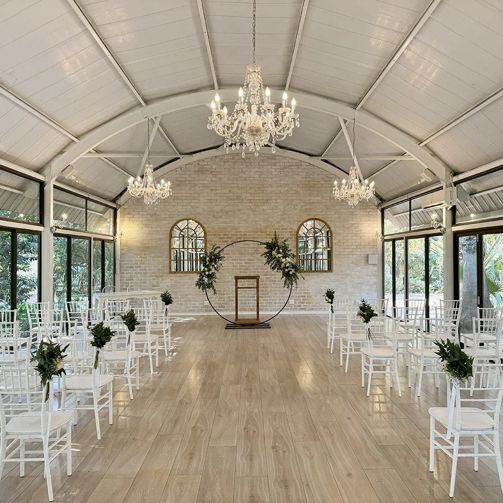 Altar end of the Glass Dome Chapel with chandeliers, pale brick and a circular floral frame