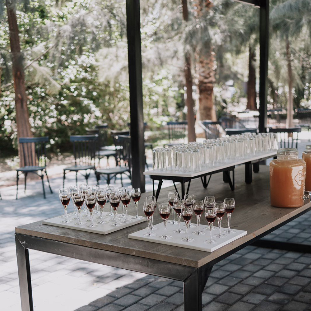 Trays of welcome drinks arranged on a timber table in the shaded pre-reception area