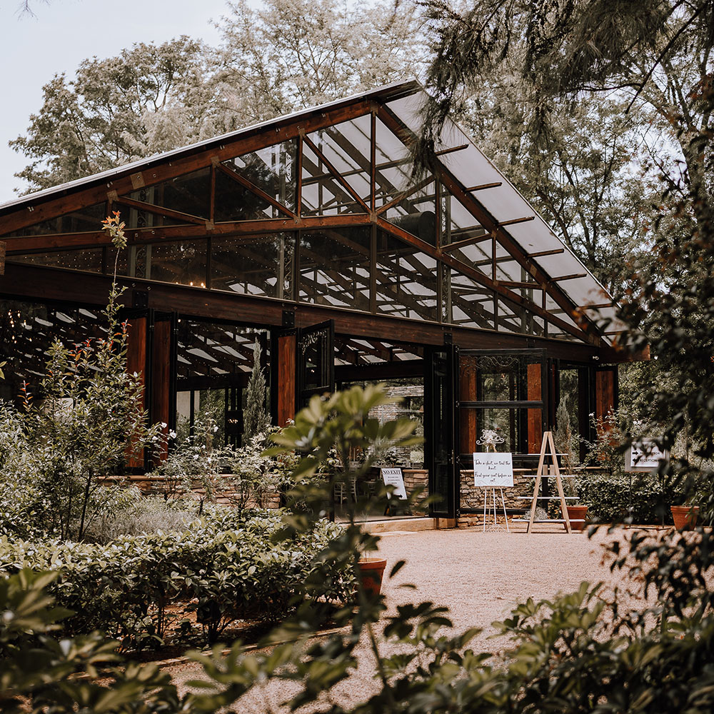 Exterior of the Bell Reception Hall framed by trees and garden foliage