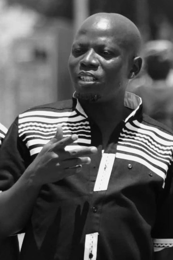 The Groomsman — black-and-white photograph of a man speaking mid-gesture