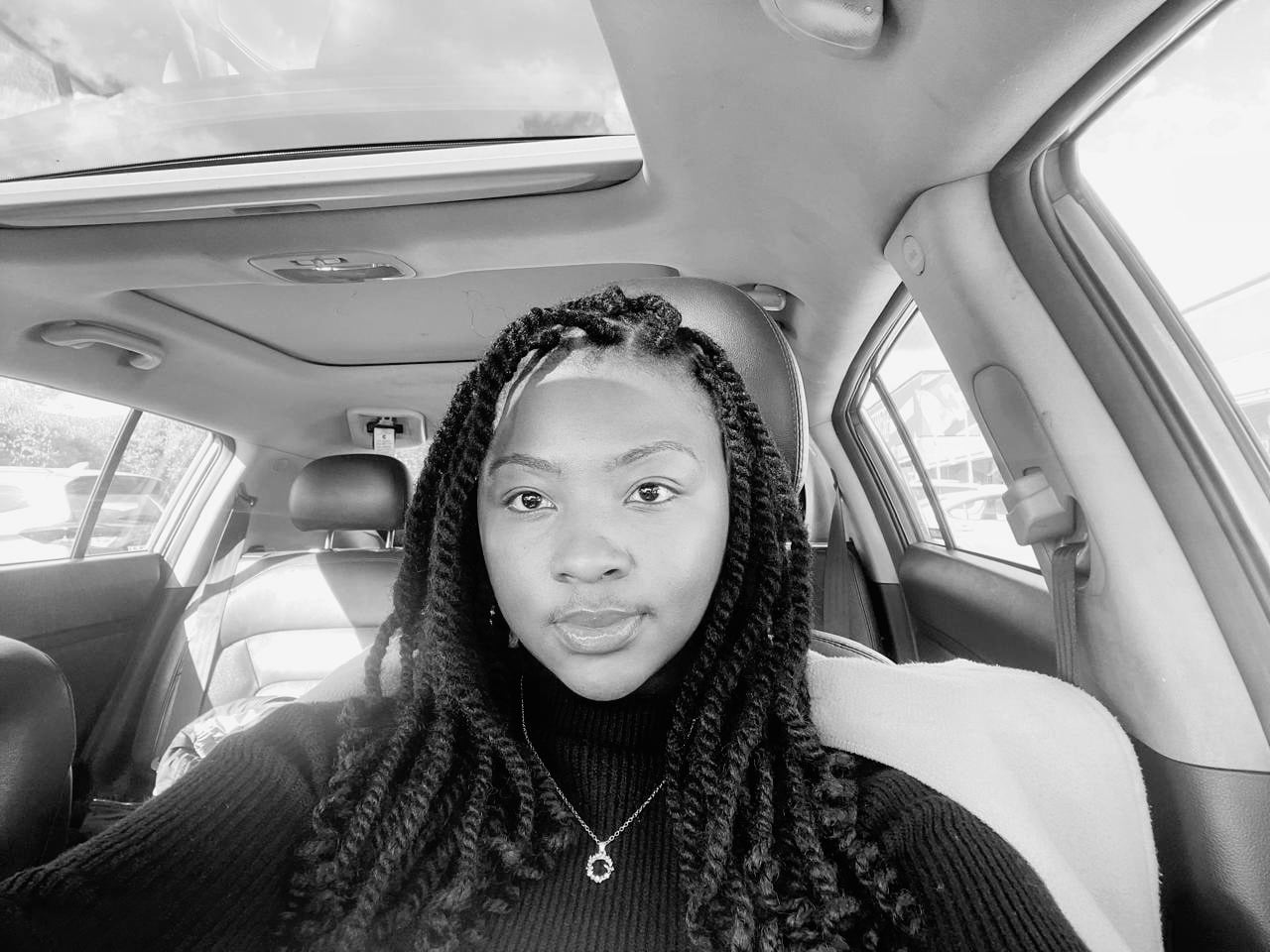 A Bridesmaid — black-and-white car selfie of a woman with twisted braids