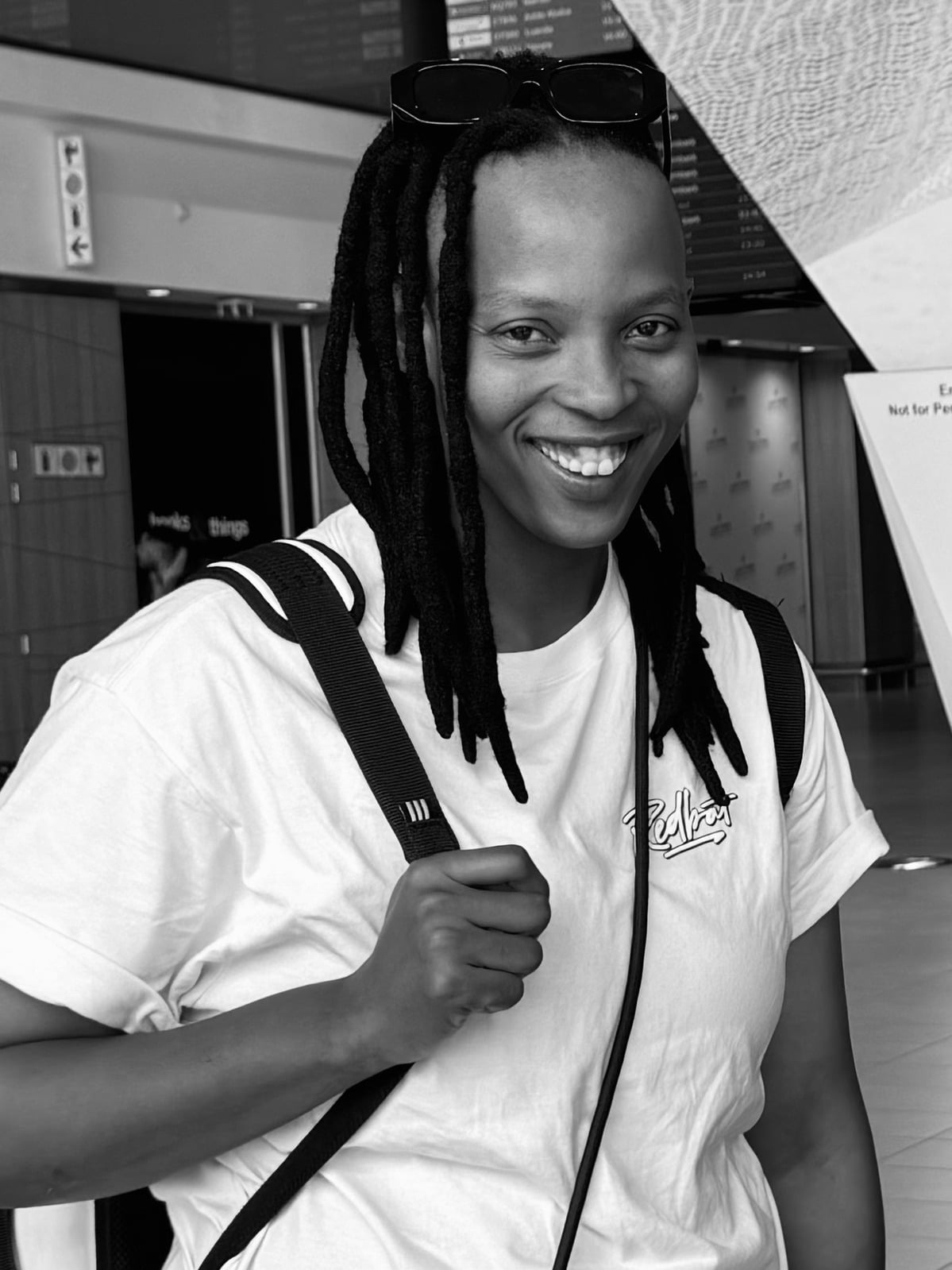 The Groom's Sister — black-and-white portrait of a smiling woman with locs